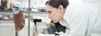 Close up of Silicone technician visually scrutinising a Silicone foot prosthesis during production