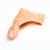 Close up of partial silicone thumb digit prosthesis with a white skin tone