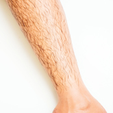 Close up Silicone forearm prosthesis with realistic body hair detailing with a white skin tone