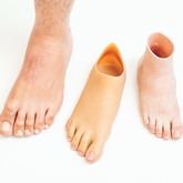 Three Silicone Feet Prostheses line up in a row, first foot has added detail of hairs