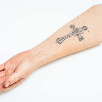 A close up of a Silicone hand and forearm prosthesis with a forearm tattoo
