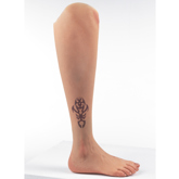 Side profile of Silicone leg prosthesis with tattoo above ankle with a white skin tone