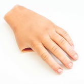 Close up of partial silicone digit prosthesis with a white skin tone and all four fingers